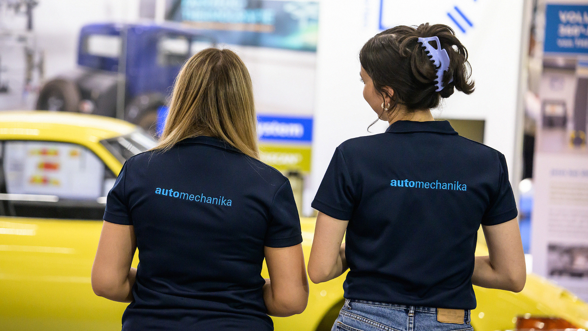 Two women's backs with Automechanika lettering