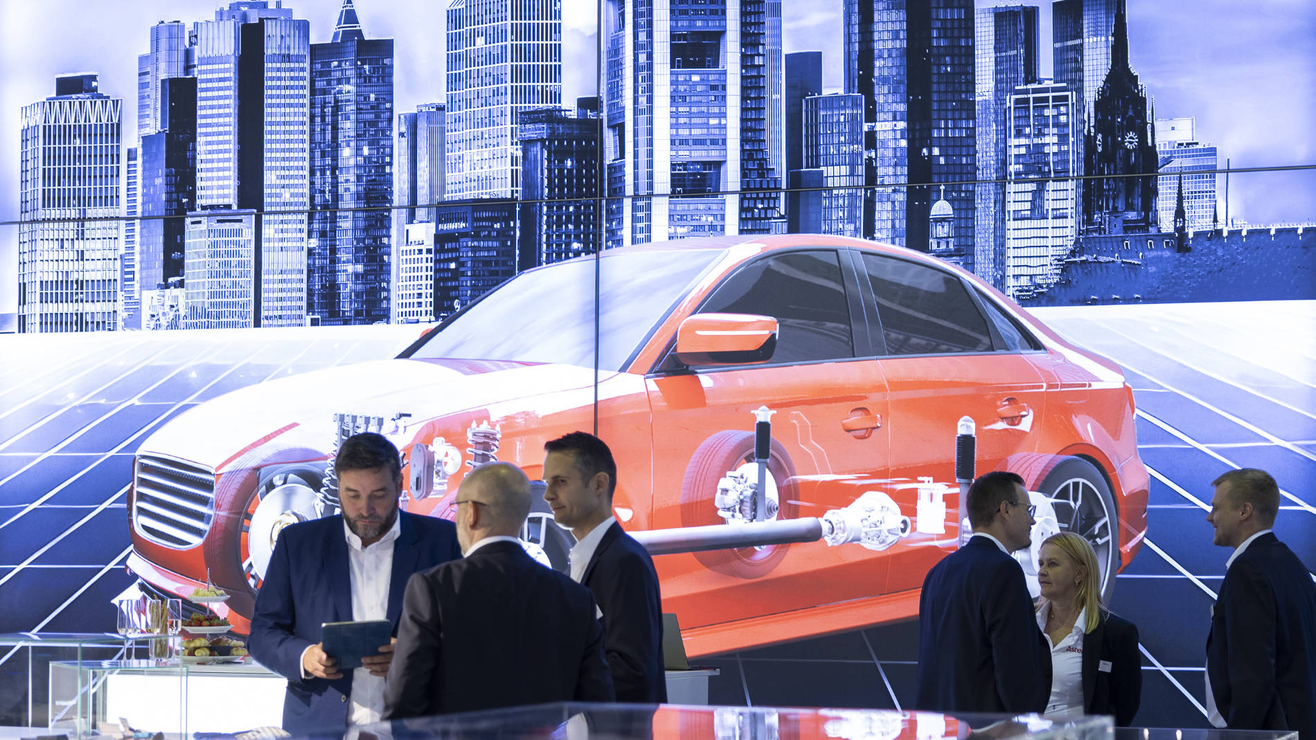 Besucher und Aussteller vor einem Auto-Display